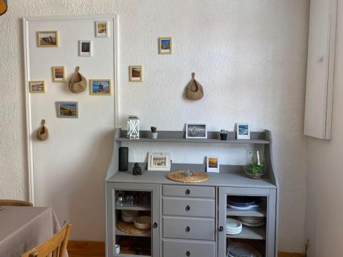 um armário cinzento num quarto com fotografias na parede em Villa Soulacaise Plage et Centre em Soulac-sur-Mer