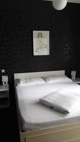 Una cama en un dormitorio con un cuadro en la pared. en Hotel Goldene Spinne, en Viena