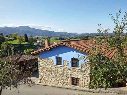 a stone house with a red roof at Belvilla by OYO Cottage in Nava with Swimming Pool in Nava