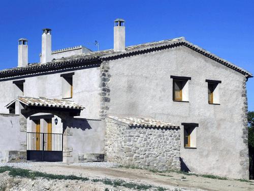 une grande maison blanche avec un bâtiment en pierre dans l'établissement 17th century farmhouse in Bages near Montserrat, à Castellfullit del Boix