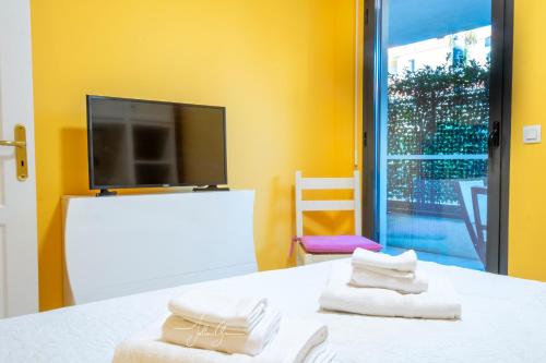 Cette chambre dispose d'une télévision et d'une table avec des serviettes. dans l'établissement Royal Cap, à Villeneuve-Loubet