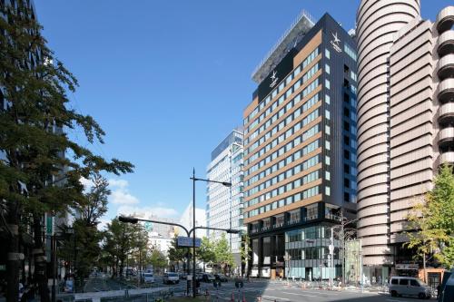 a city street with tall buildings and a blue sky at Candeo Hotels Osaka Shinsaibashi in Osaka