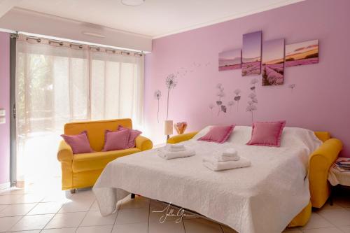 - une chambre avec un grand lit et deux chaises jaunes dans l'établissement Royal Cap, à Villeneuve-Loubet