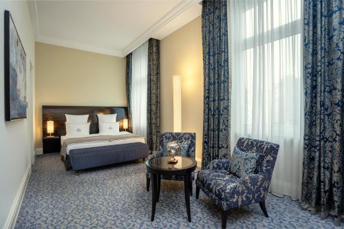 a hotel room with a bed and a chair at Hotel Atlantic Hamburg, Autograph Collection in Hamburg