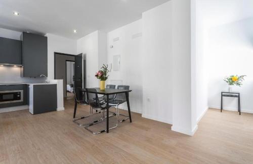 a room with a table and chairs and a kitchen at La La Suites Rianal in Jerez de la Frontera