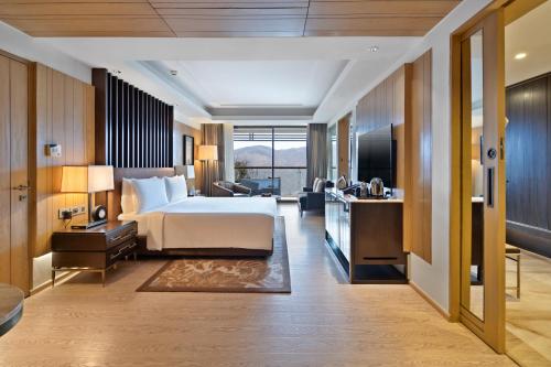 Habitación de hotel con cama, escritorio y lavabo. en JW Marriott Mussoorie Walnut Grove Resort & Spa, en Mussoorie