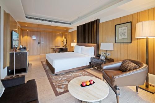 a hotel room with a bed and a couch at JW Marriott Mussoorie Walnut Grove Resort & Spa in Mussoorie