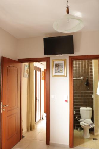a bathroom with a toilet and a tv on the ceiling at Großes Haus mit traumhaftem Ausblick in Georgioupolis