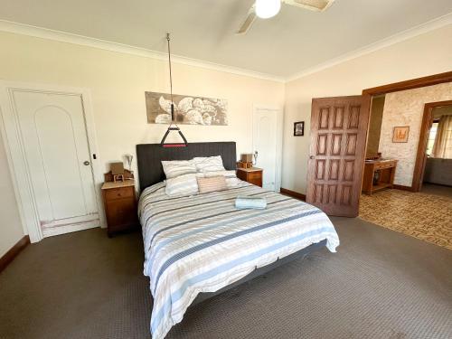 a bedroom with a large bed with a blue book on it at Ardgreian in Safety Bay