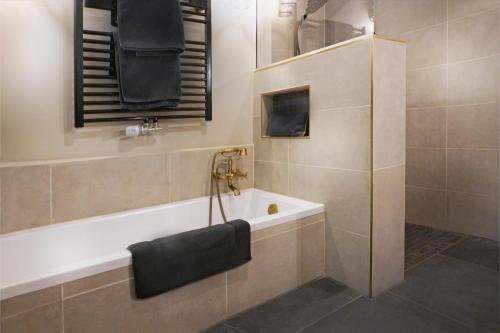 a bathroom with a bath tub and a sink at Black Suite 2 Luxus in Alsternähe in Hamburg