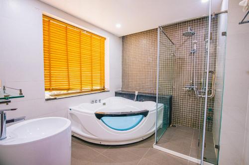 a bathroom with a tub and a glass shower at Villa FLC Sầm Sơn Thanh Hoá in Sầm Sơn