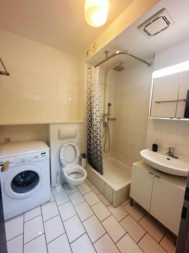 een badkamer met een toilet, een wastafel en een wasmachine bij Messe Flughafen nah mit Waschmaschine in Düsseldorf