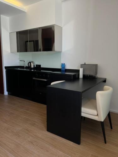 a kitchen with a black table and a white chair at Sea breeze White Villa 1 in Bilgah