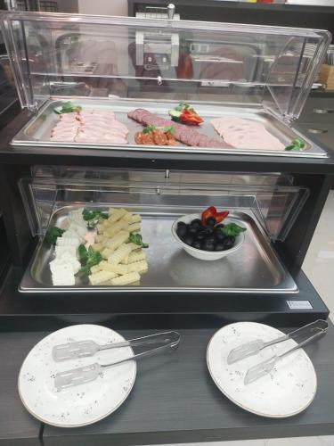 a display case filled with different types of food at Hotel Novotheos in Oradea