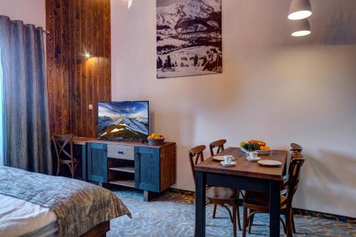um quarto de hotel com uma cama, uma mesa e uma televisão em Strachan Family Jasná em Demanovska Dolina