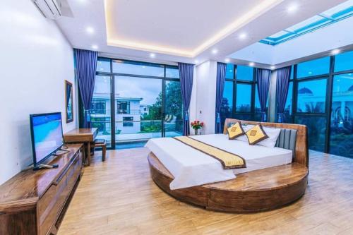 um quarto com uma cama grande e uma televisão de ecrã plano em Villa FLC Sầm Sơn Thanh Hoá em Sam Son