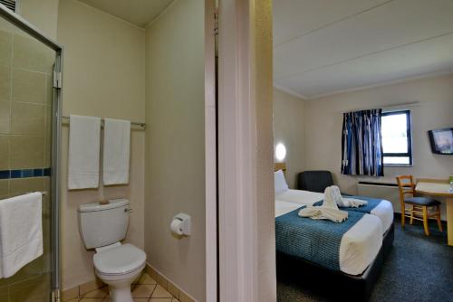 a hotel room with a bed and a toilet at Road Lodge Centurion in Centurion