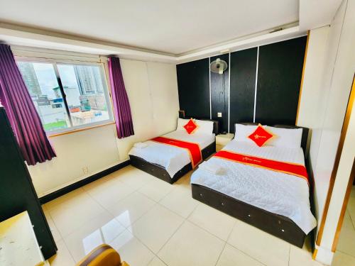 een hotelkamer met 2 bedden en een raam bij Istars Hotel in Ho Chi Minh-stad