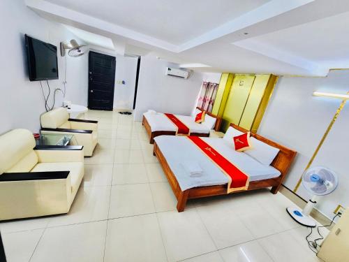 une chambre d'hôtel avec deux lits et un canapé dans l'établissement Istars Hotel, à Hô-Chi-Minh-Ville