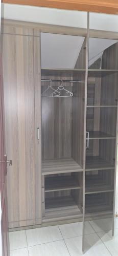 un armario con estanterías de madera y una puerta de cristal en Zedek Furnished Apartment 203, en Nairobi