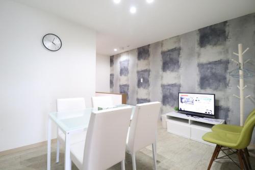 a dining room with a table and a computer on a wall at Tsuruhashi East III in Osaka