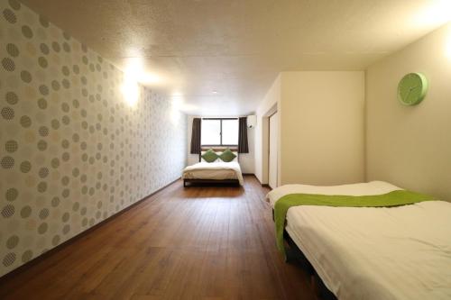 een kleine kamer met twee bedden en een raam bij Tsuruhashi East III in Osaka