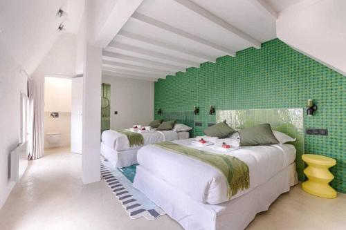 Cette chambre comprend 3 lits et un mur vert. dans l'établissement Les Halles - Luxurious & colorful 4BD for 16 guest, à Paris