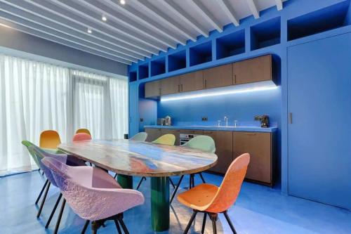 une salle à manger avec une table et des chaises en bois dans l'établissement Les Halles - Luxurious & colorful 4BD for 16 guest, à Paris