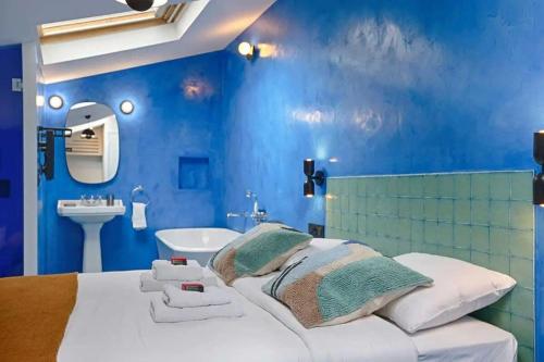 - une chambre bleue avec un grand lit et un lavabo dans l'établissement Les Halles - Luxurious & colorful 4BD for 16 guest, à Paris