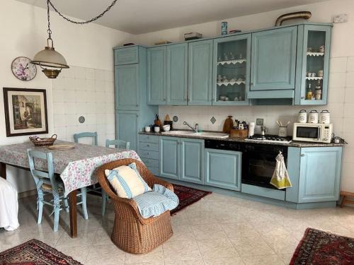 Vestignè的住宿－Casa Relax in Canavese，厨房配有蓝色橱柜和桌椅