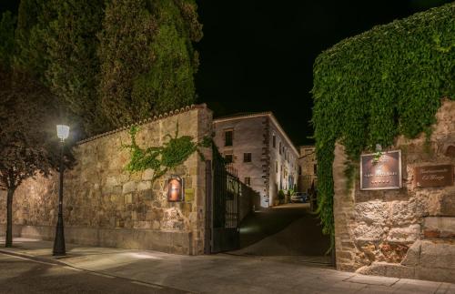 a stone building with a gate at night at Hospes Palacio de San Esteban, a Member of Design Hotels in Salamanca