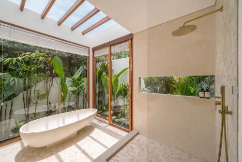 Das Bad ist mit einer Badewanne und einer Glasdusche ausgestattet. in der Unterkunft Villa Inka - Tropical Modern 1BR Villa in Pererenan Beachside in Canggu