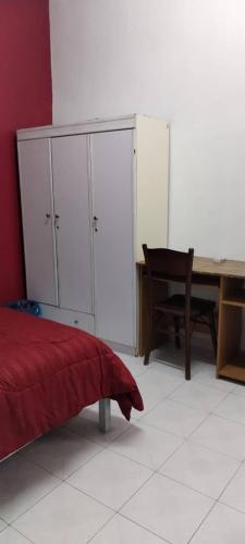 Schlafzimmer mit einem Bett, einem Schreibtisch und einem Schrank in der Unterkunft NASP LEGACY GUEST HOUSE in Jasin