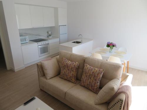 a living room with a couch and a table and a kitchen at Apartamento Centinela Do Mar in O Pindo