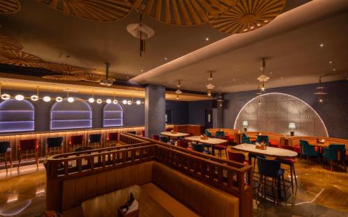 a restaurant with tables and chairs in a room at Palm Springs Resort in Nashik