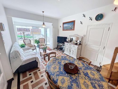 un salon avec une table et quelques chaises dans l'établissement Maison à 100m de la plage, jardin privé, wifi gratuit, proche commerces et activités balnéaires - FR-1-361-113, à Jullouville