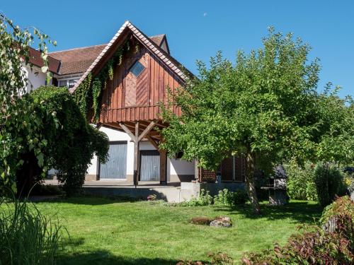 una casa con un albero nel cortile di Cozy Apartment in Schwenningen with Garden a Villingen-Schwenningen