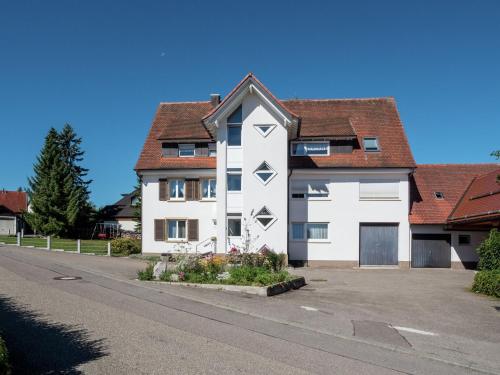 a white house with a brown roof at Cozy Apartment in Schwenningen with Garden in Villingen-Schwenningen