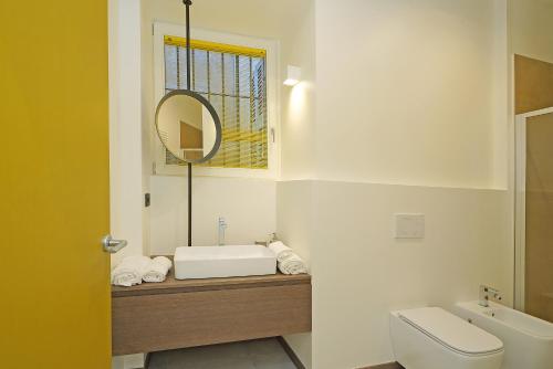 ein Badezimmer mit einem Waschbecken, einem WC und einem Spiegel in der Unterkunft Gemhouse Ambra garda lake in Gargnano