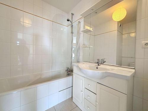 een witte badkamer met een wastafel en een douche bij Appartement Granville, 1 pièce, 2 personnes - FR-1-361-337 in Granville