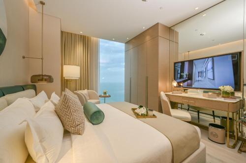 a bedroom with a large bed and a television at Onyx Rotana in Manama