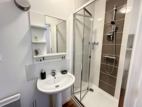 une salle de bain avec un lavabo et une douche dans l'établissement Appartement cosy avec ascenseur à 150m de la plage et casino, wifi gratuit - FR-1-361-330, à Granville