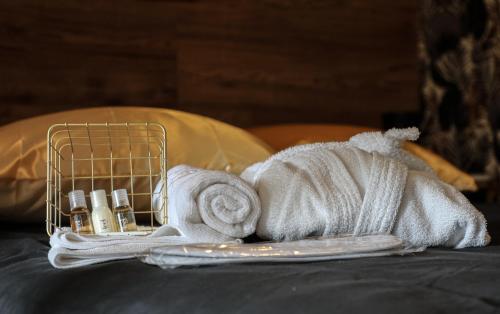 einen Haufen Handtücher und Kosmetik auf einem Bett in der Unterkunft Le Premium - Suite Spa Privatif in Pontavert