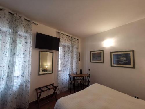 a bedroom with a bed and a table and curtains at Locanda dell'Arcangelo in Rocca Massima