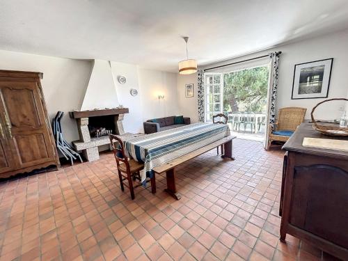 un salon avec une table et une cheminée dans l'établissement Maison avec Terrasse à 100m de la Plage, Jardin Clos, 3 Chambres, Proche Mont Saint-Michel - FR-1-361-457, à Jullouville
