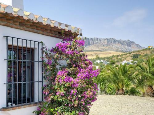 a building with purple flowers on the side of it at Guest house in a traditional Andalusian country estate in La Joya