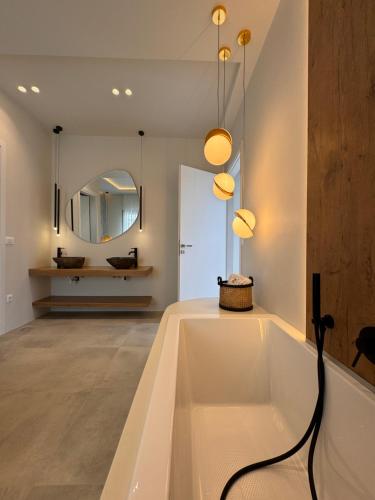 a bathroom with a bath tub and a mirror at Poema Antiparos in Antiparos