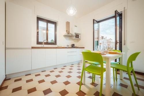 a kitchen with a table and green chairs at La Casa di Vittoria Apartment Sea View - Housea in Polignano a Mare