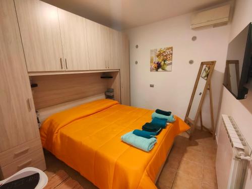 um quarto com uma cama laranja e toalhas em Discesa Marina em Ventimiglia