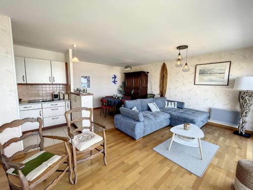 un salon avec un canapé bleu et une cuisine dans l'établissement Appartement 2 chambres près de la plage avec balcon, ascenseur, garage et Wi-Fi gratuit - FR-1-361-487, à Granville